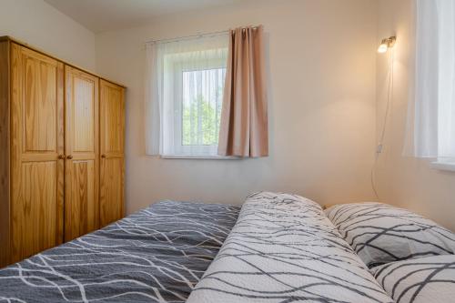 a bedroom with a bed and a window at Apartmány Nad rybníky in Horní Planá