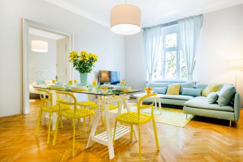 a living room with a table and chairs and a couch at Tyzenhauz Grand Apartaments in Kraków