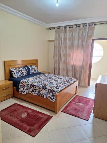 een slaapkamer met een bed en een raam met tapijten bij Home Sweet Homes in Rabat