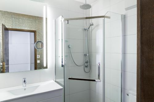 a bathroom with a glass shower and a sink at Hotel Hellers Twenty Four I -24h-Check-In- in Friedrichshafen