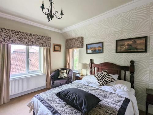 a bedroom with a bed and a window and a chandelier at Arrandale Lodge in Norwich