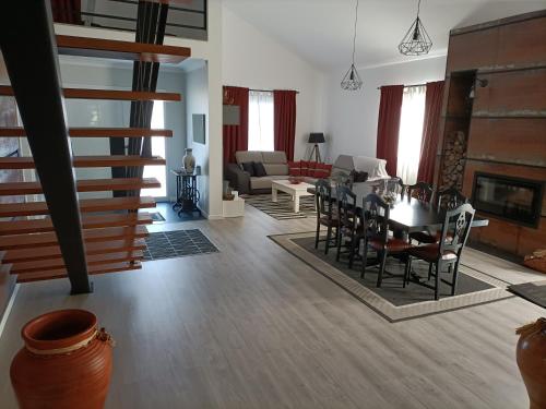 a dining room and living room with a table and chairs at Sons da Ribeira in Povoação