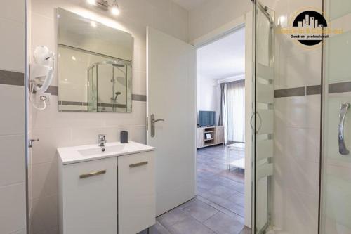 La salle de bains blanche est pourvue d'un lavabo et d'une douche. dans l'établissement Apartamento El Noray, à Torremolinos