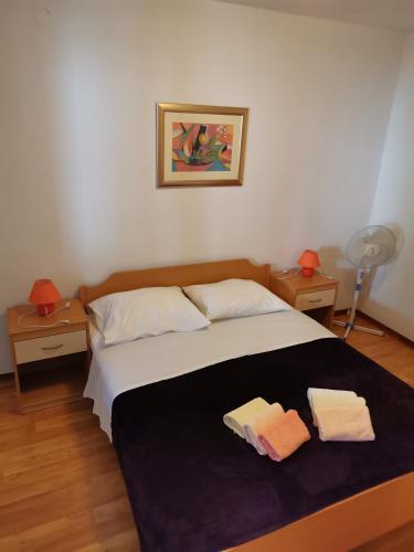 a bedroom with a bed with two towels on it at Apartments Kokotic in Bol