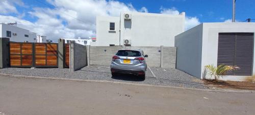 a small car parked in front of a house at Bois Mapou Self Catering Apartments Unit 103 in Rivière Noire