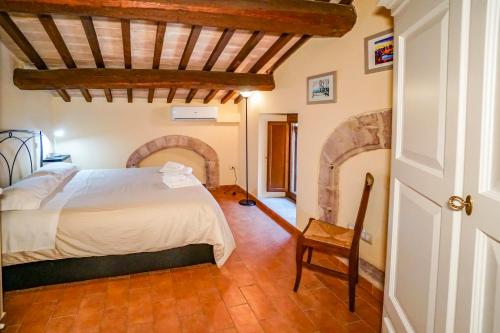 een slaapkamer met een bed en een houten vloer bij Maison Quintavalle 20 in Assisi