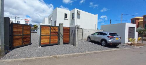 a car parked in front of a house with two gates at Bois Mapou Self Catering Apartments Unit 103 in Rivière Noire