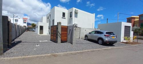 a car parked in front of a house at Bois Mapou Self Catering Apartments Unit 103 in Rivière Noire