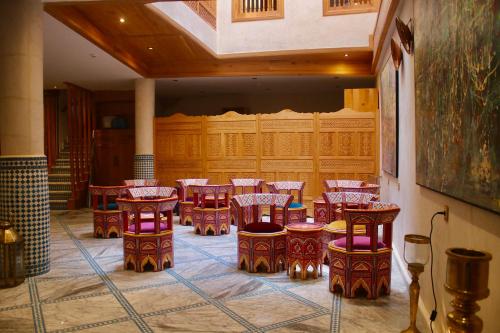 una stanza con un mucchio di tavoli e sedie di Riad Mellah a Essaouira