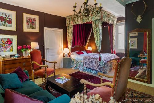ein Wohnzimmer mit einem Bett und einem Sofa in der Unterkunft Les Jardins Haute Couture in Huismes
