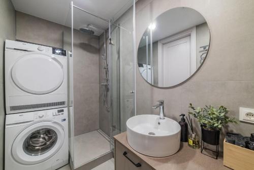 a bathroom with a sink and a washing machine at Frida Apartment in Šiauliai