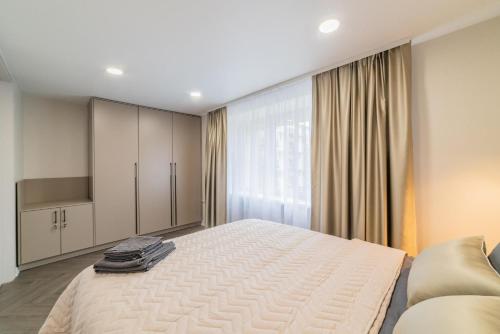 a bedroom with a large bed and a couch at Frida Apartment in Šiauliai