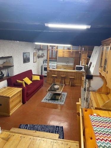 salon z czerwoną kanapą i kuchnią w obiekcie Casa Hope w mieście Vasanello