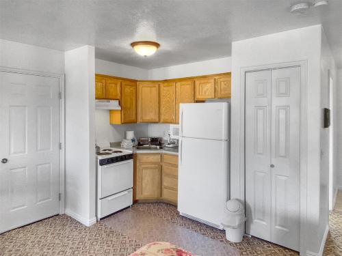 a kitchen with a white refrigerator and wooden cabinets at Robins Roost b in Hatch