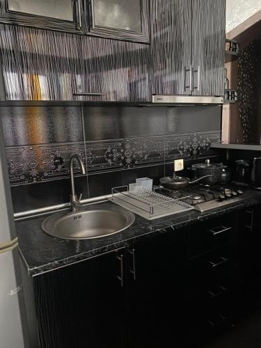 Dea Apartments في باتومي: طاولة مطبخ مع حوض وموقد