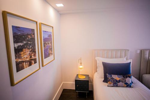 a bedroom with a bed with two pictures on the wall at 262 Boutique Aliados in Porto