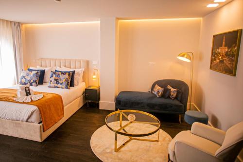 a bedroom with a bed and a chair and a table at 262 Boutique Aliados in Porto