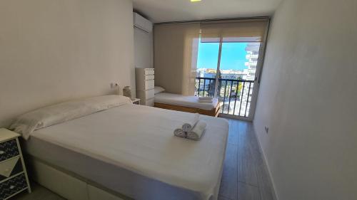 a bedroom with a large white bed and a balcony at Apartamento Acacias IV -5 in Benidorm