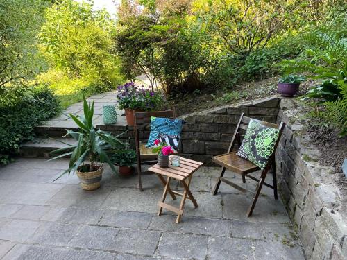a patio with two chairs and a table with flowers at 1 Zimmer Whg Waldfischbach in Waldfischbach-Burgalben