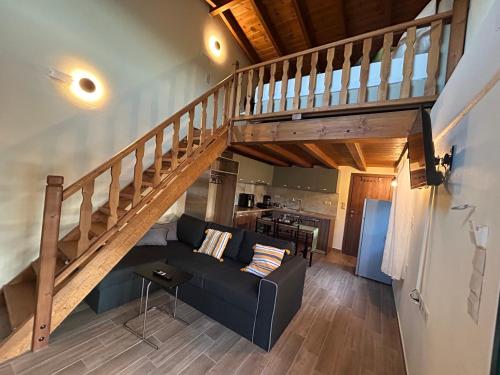 a living room with a couch and a staircase at Green Olive Studios in Agios Mamas