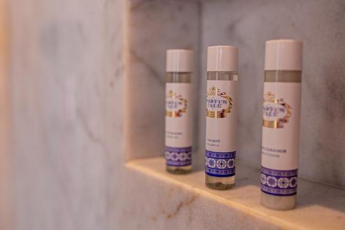 three bottles of moisturizers sitting on a shelf in a bathroom at 262 Boutique Aliados in Porto