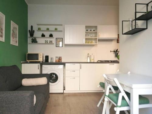 uma sala de estar com um sofá, uma mesa e uma cozinha em Appartamento Verde em Como