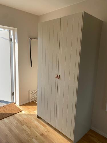 a white closet with a door in a room at Bedinge Golfklubb hotell in Beddinge Strand