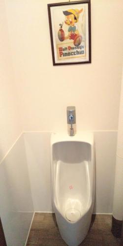 a urinal in a bathroom with a picture on the wall at 小樽民泊太田1号館 in Otaru