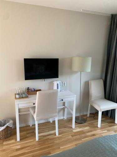 a room with a desk with a tv and a chair at Bedinge Golfklubb hotell in Beddinge Strand