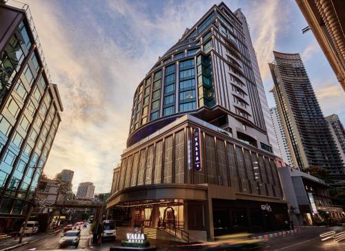 a tall building in the middle of a city at Valia Hotel Bangkok in Bangkok