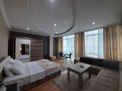 Hotel Royal Palace في باتومي: غرفة نوم بسرير واريكة وطاولة