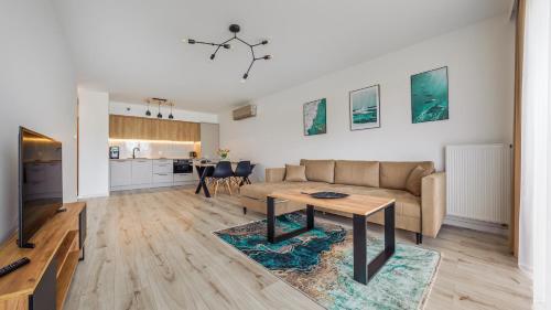 a living room with a couch and a table at Porta Mare Marina, Sun & Snow in Dziwnów