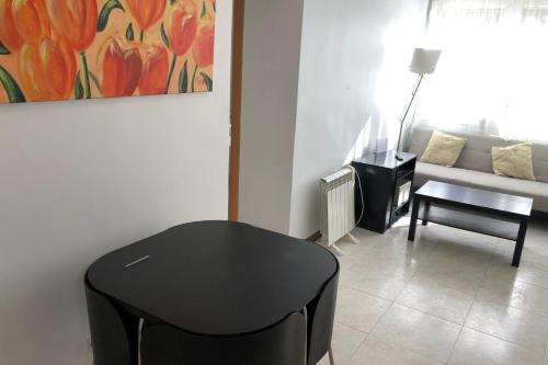 - un salon avec une table noire et un canapé dans l'établissement New! Apartment for 3 people near Fira Gran Via, à L'Hospitalet de Llobregat