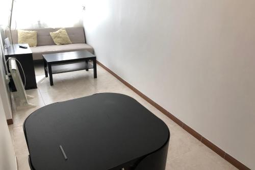- un salon avec un pouf noir et un canapé dans l'établissement New! Apartment for 3 people near Fira Gran Via, à L'Hospitalet de Llobregat