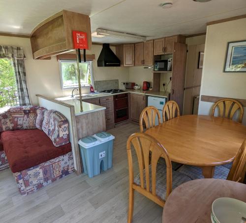 a kitchen and living room with a table and a couch at Glebe Farm Holidays in Newport