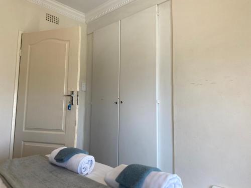 a bedroom with a bed with two pillows on it at Safari Apartments -Beautiful 3 bedrooms, 10-seater dining , TV room, Garden & Pool in Johannesburg