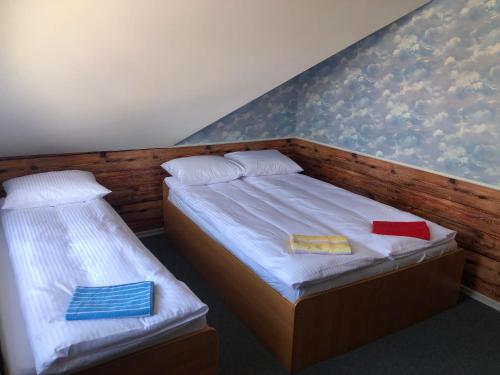 Dos camas en una habitación con toallas. en Noclegi Rynek 12, en Lesko