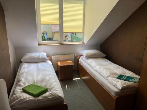 レスコにあるNoclegi Rynek 12のベッド2台と窓が備わる小さな客室です。