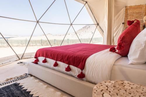 Bett in einem Zimmer mit einem großen Fenster in der Unterkunft Desert Sands Dakhla in Ad-Dakhla