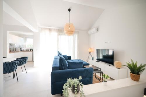 a living room with blue chairs and a tv at Apartments Mila M in Sveti Filip i Jakov