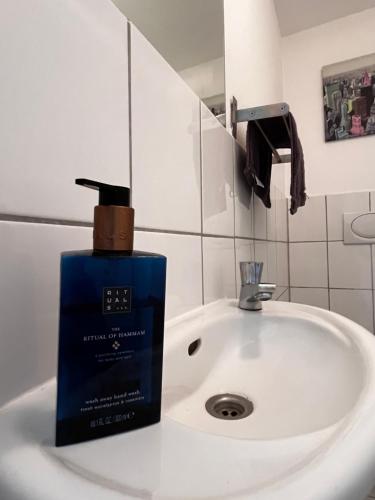 una botella de jabón en el lavabo del baño en Traumloft Maisonette, en Düsseldorf