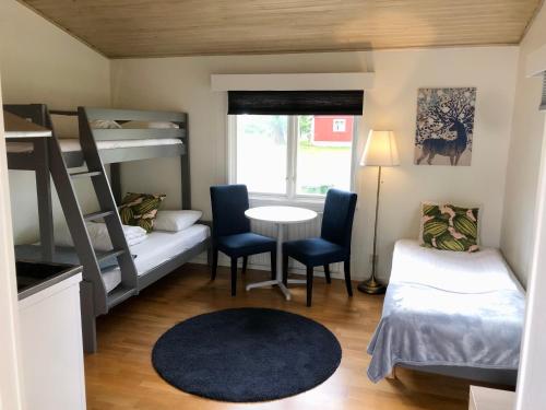 a small room with bunk beds and a table and chairs at Vättersmålen Stuga in Gränna