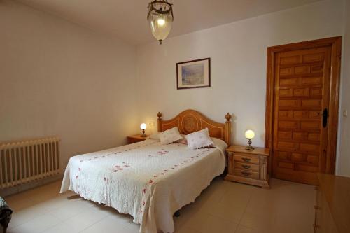a bedroom with a bed and a wooden door at CASASBLANCAS. Casa nr 6 in Mecina Bombarón