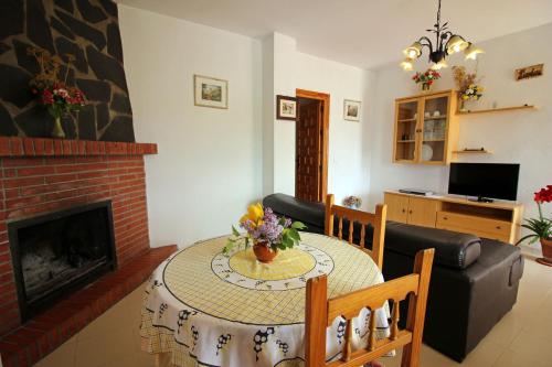 a living room with a table and a fireplace at CASASBLANCAS. Casa nr 6 in Mecina Bombarón