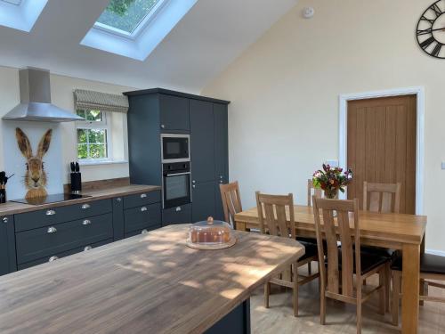 a kitchen with a wooden table and a dining room at The Haystack Lodge in Tarporley