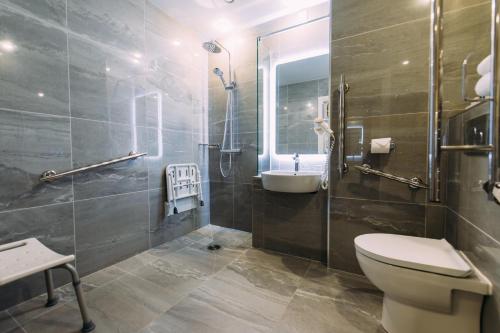 a bathroom with a toilet and a sink and a shower at Armagh City Hotel in Armagh