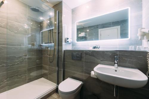 a bathroom with a sink and a toilet and a shower at Armagh City Hotel in Armagh