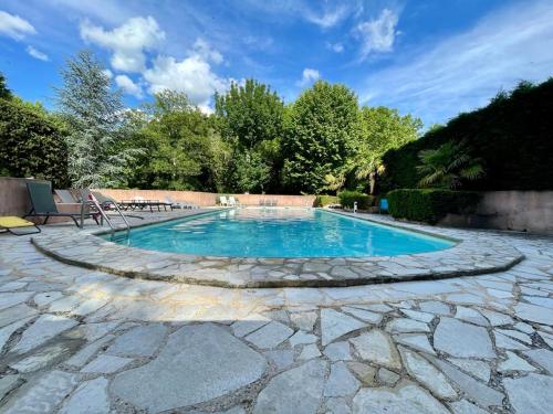 una piscina con un passaggio in pietra intorno ad essa di Notre Dame des Anges DUPLEX a Rustrel