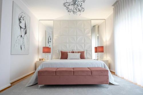 een slaapkamer met een groot bed en een roze bank bij Inviting - Villa Mar in Árvore