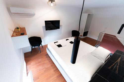 a white room with a white bed and a tv at Wal49 Suite in Bari